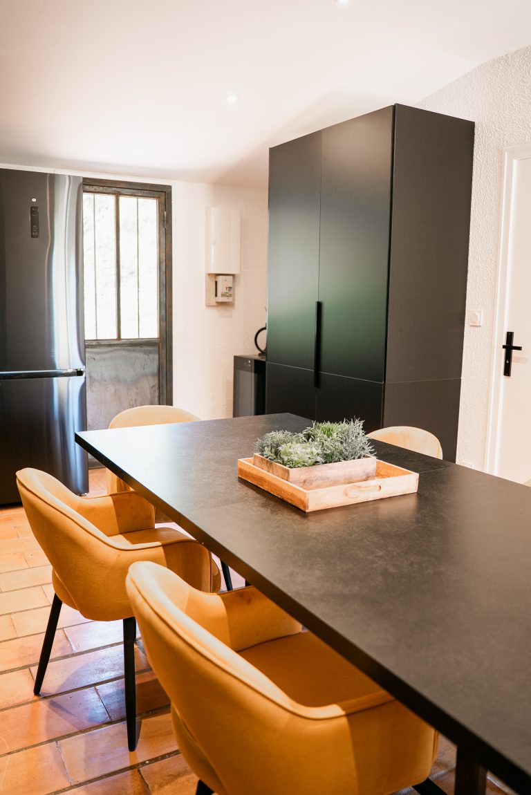 Grande table à manger en bois dans la cuisine de la villa Ô Sud Location