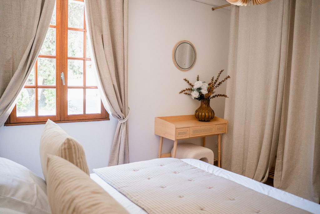 Lit double dans la chambre 1 avec une décoration aux tons beige, blanc et marron