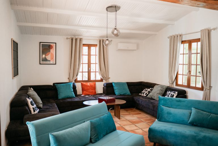 Salon spacieux avec deux canapés-lits et un grand canapé d’angle à la villa Ô Sud Location