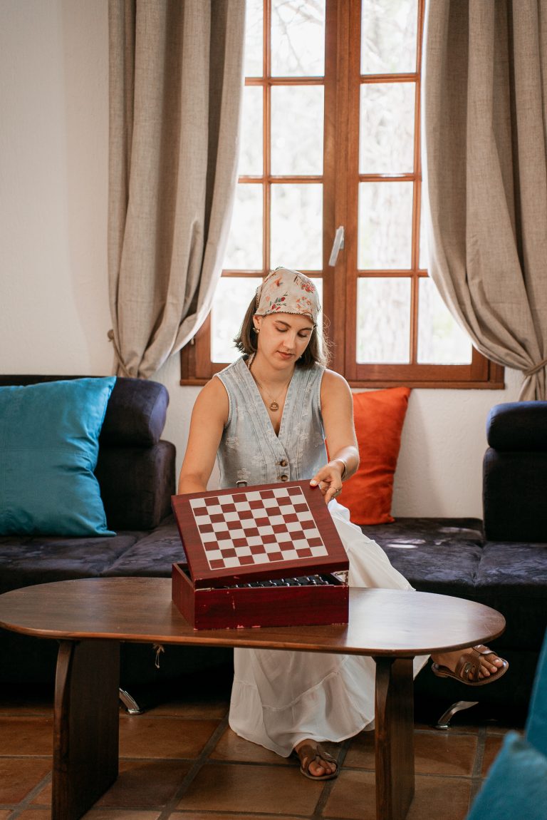 Femme jouant aux échecs dans le salon de la villa Ô Sud Location