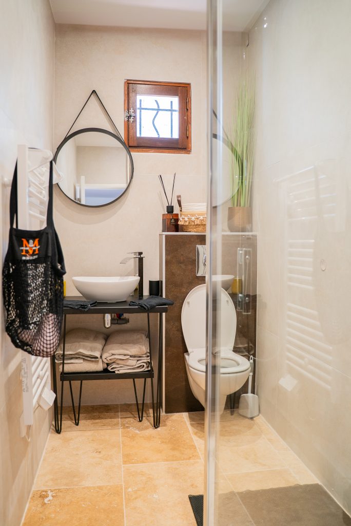 Salle de bain complète avec douche, vasque et décoration naturelle à la villa Ô Sud Location