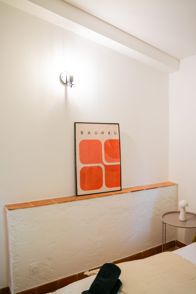 Mur de la chambre 2 avec un cadre orange décoratif posé dessus