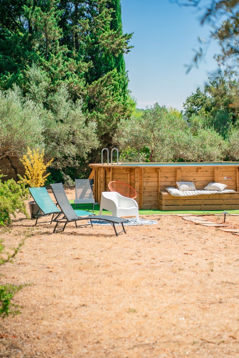 Piscine entourée de jardin verdoyant avec mobilier de jardin élégant