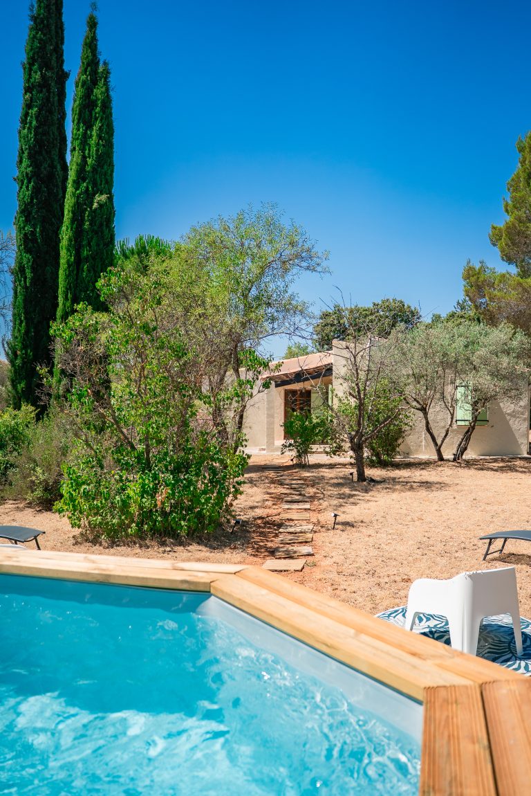 Piscine entourée d’un jardin verdoyant et bien entretenu