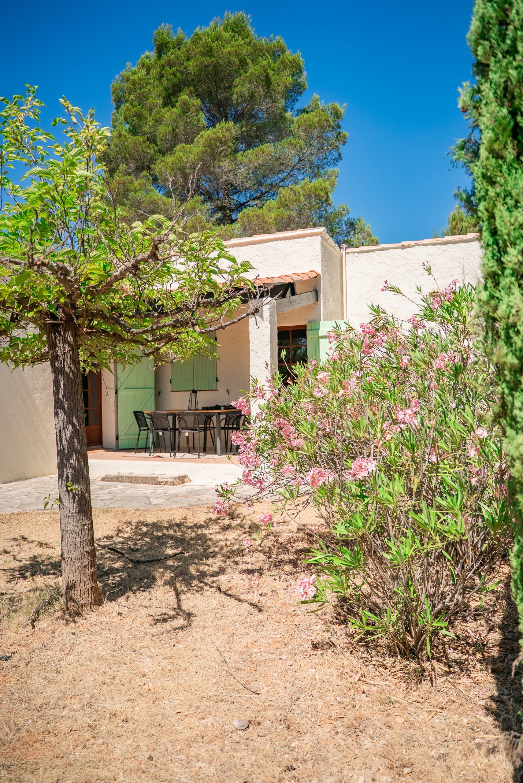Vue de l’arrière de la maison avec terrasse extérieure et mobilier de jardin