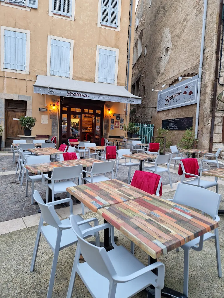 Terrasse ombragée de la Brasserie de la Fontaine à Cotignac, sur la place du Cours